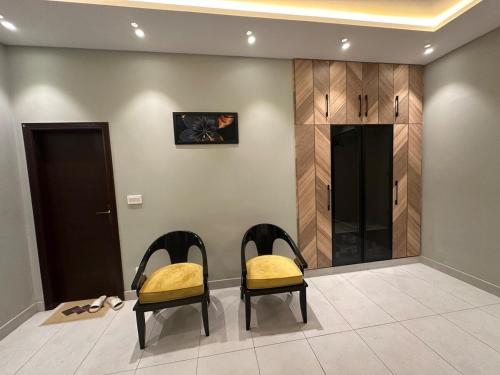 two chairs with yellow cushions sitting in a room at 2BR Modern Home in the heart of lahore New gardentown in Lahore