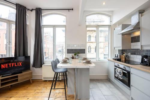 a kitchen with a table and chairs in a room at Central Sleeps 6 Stunning 2 Bed by City SuperHost in Manchester
