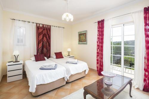 ein Schlafzimmer mit zwei Betten und einem Tisch in der Unterkunft Villa Botanica in Canhestros