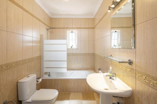 ein Badezimmer mit Toilette, Waschbecken und Badewanne in der Unterkunft Villa Botanica in Canhestros
