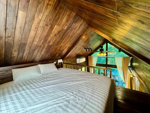 a bedroom with a bed in a wooden ceiling at An House in Sóc Sơn