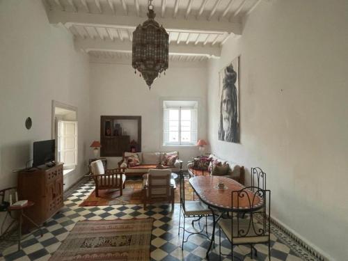 a living room with a table and a couch at Appartement Riad Sidi Magdoul in Essaouira