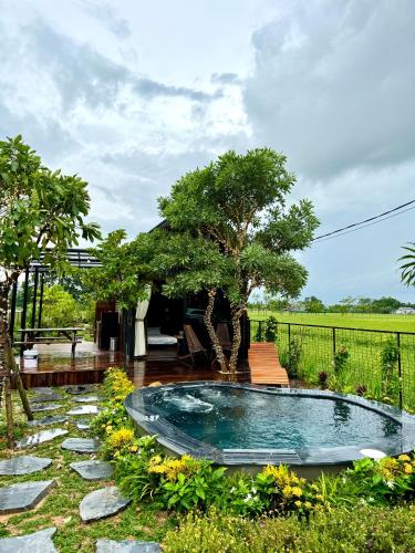 a small pool in a garden with a tree at An House in Sóc Sơn
