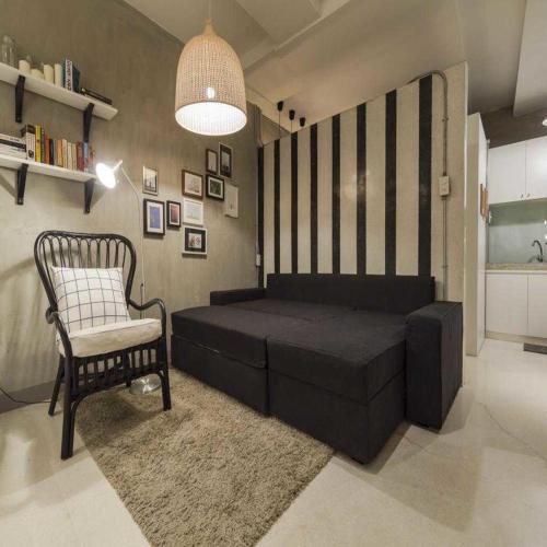 a living room with a bed and a chair at Collection O Jasaen Stylish Unique Hotel in Bangkok
