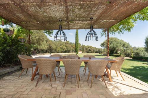 a wooden table and chairs under a pergola at Can Font de Muntanya in Cruïlles