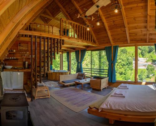 a large room with a bed and a living room at Cuneli bungalov in Çamlıhemşin