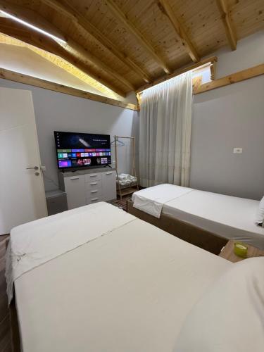 a room with two beds and a tv in it at Villa REJA Hamallaj in Draçi