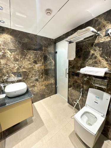a bathroom with a toilet and a sink at Plaza 14 in Jammu