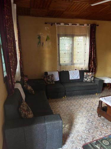 a living room with a couch and a window at Live like a local in Morogoro in Morogoro