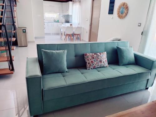 a blue couch with pillows in a living room at LIVAS Residence in Tympáki
