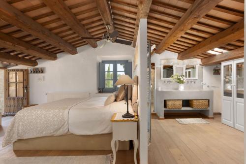 a bedroom with a large bed and a bathroom at Can Font de Muntanya in Cruïlles