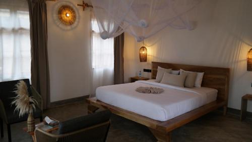 a bedroom with a large white bed and a chair at Our Stay Mlima in Arusha