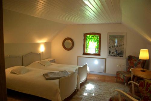 a bedroom with two beds and a window and a table at Trolleberg Bed & Breakfast in Veberöd