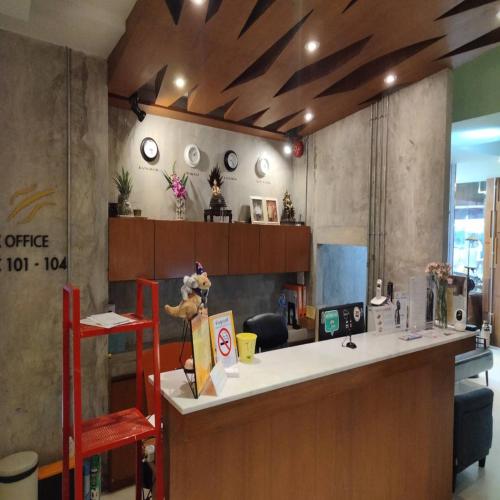 バンコクにあるCollection O Jasaen Stylish Boutique Hotelの赤い椅子とカウンターのあるレストランのバー