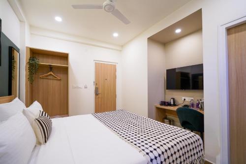 a hotel room with a bed and a desk at Olive Hotel Hoodi by Embassy Group in Bengaluru