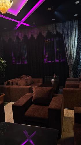 a living room with brown couches and purple lighting at City Hotel Baku in Baku