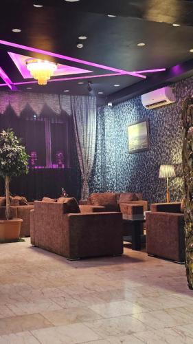 a living room with brown couches and purple lighting at City Hotel Baku in Baku