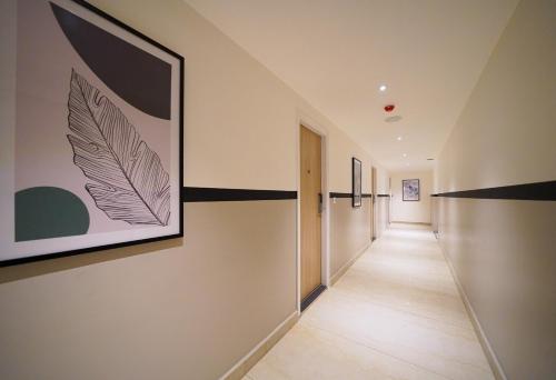 a hallway with black and white paintings on the walls at Olive Hotel Hoodi by Embassy Group in Bengaluru