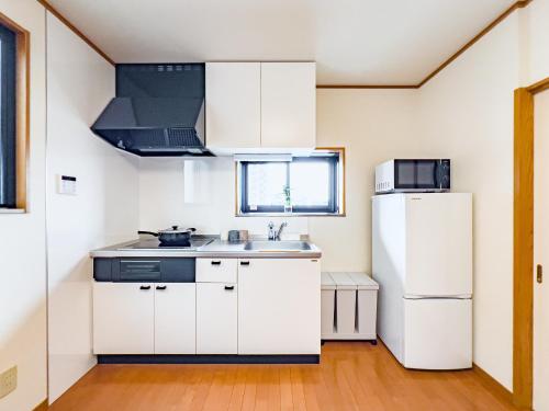 a kitchen with white cabinets and a refrigerator at Skytree STAR 11 Hotel in Tokyo