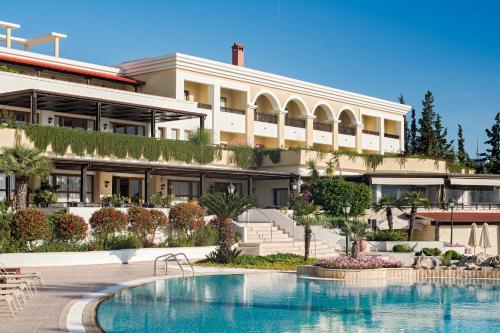 a hotel with a swimming pool in front of a building at Aegean Melathron Thalasso Spa Hotel in Kallithea Halkidikis