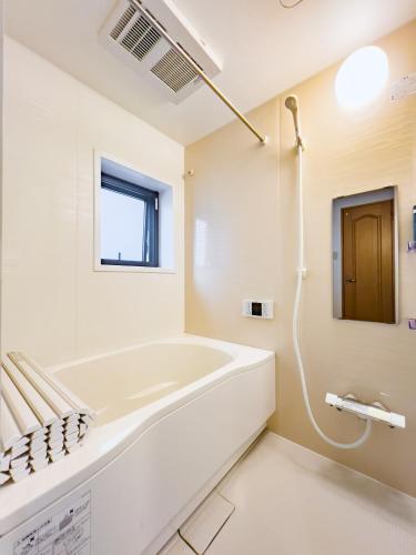 a white bathroom with a tub and a window at Skytree STAR 11 Hotel in Tokyo