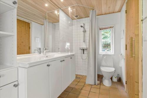 a white bathroom with a sink and a toilet at 8554-Grenaa-Bertavej-25 in Brøndstrup