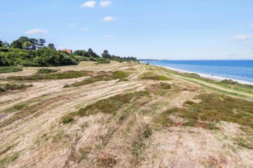 a dirt hill next to a beach with the ocean at 8916-Allingabro-Borgmestervangen-16 in Allingåbro
