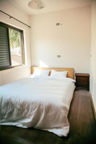 - un lit blanc dans une chambre avec fenêtre dans l'établissement 80 m quadrados - 2 Allianz Suites, à São Paulo
