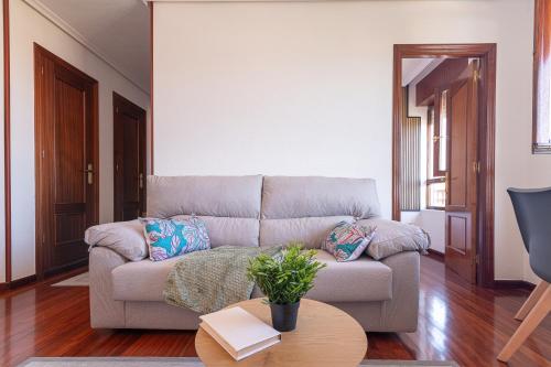 a living room with a couch and a table at Apartamento con vistas al mar in Suances