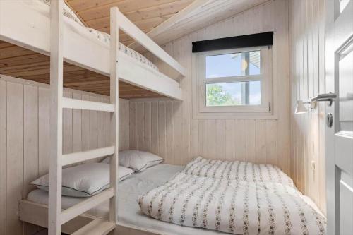 ein Schlafzimmer mit Etagenbetten in einem winzigen Haus in der Unterkunft 8842 Glesborg - Marie Nielsens Vej 5 in Glesborg