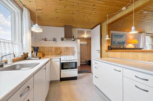 a kitchen with white appliances and a wooden ceiling at 8503-Grenaa-Ellevej-29 in Grenå