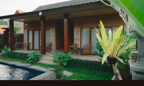 a house with a patio and a table and chairs at Bali Vanilli Villa in Sukawati