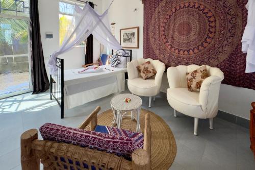 a living room with two chairs and a table at Zanzibar Lodge in Kiwengwa