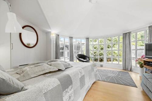 a white bedroom with a bed and a tv at 8517-Grenaa-Ellevej-31 in Grenå