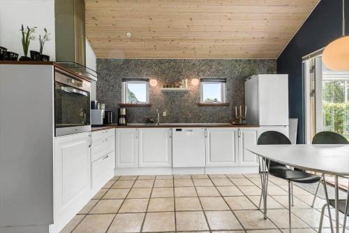 a kitchen with white appliances and a table with chairs at 8843-Glesborg-Lyngtoften-34 in Glesborg