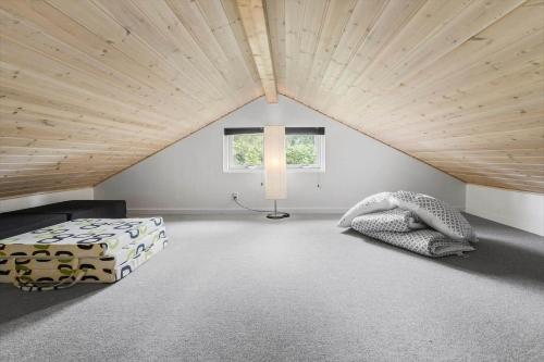 a attic bedroom with a large wooden ceiling at 8843-Glesborg-Lyngtoften-34 in Glesborg