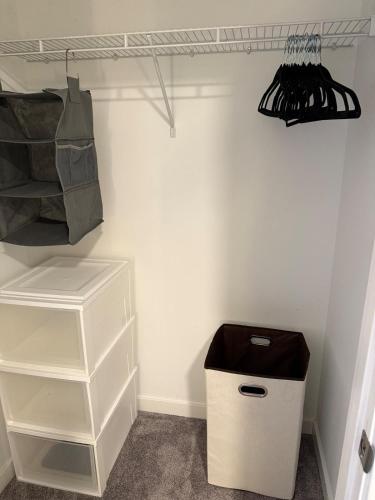 a walk in closet with a white wall and a shelf at Modern & Spacious 2BR Apartment with Gym & Parking in New Haven