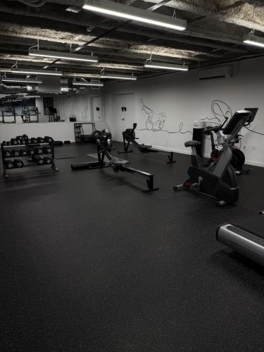 a gym with two people exercising on tread machines at Modern & Spacious 2BR Apartment with Gym & Parking in New Haven