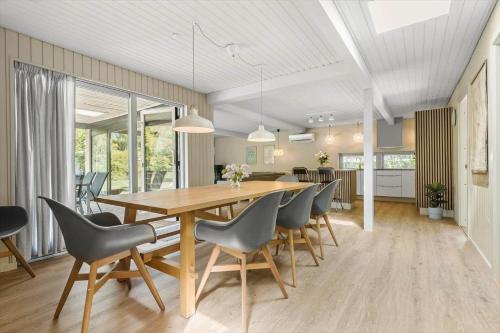 a dining room and kitchen with a wooden table and chairs at 8915-Glesborg-Zachosvej-5 in Glesborg
