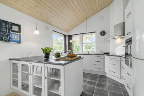 a kitchen with white appliances and a wooden ceiling at 8920-Orsted-Ternevej-16 in Ørsted
