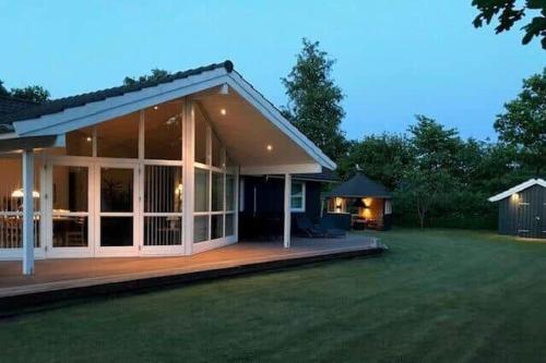 a large house with a large patio and a yard at 8920-Orsted-Ternevej-16 in Ørsted