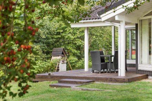 a wooden deck with chairs and a table on a house at 8995-Orsted-Alsikevej-9 in Ørsted