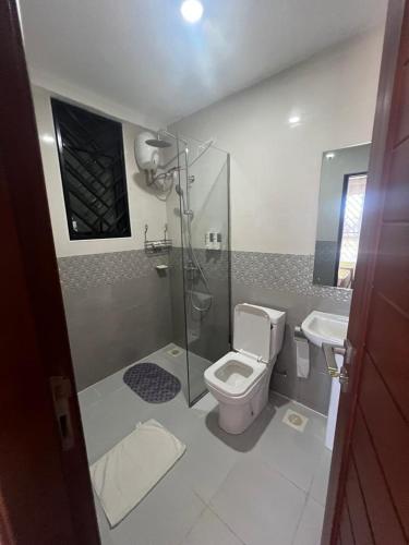 a bathroom with a shower and a toilet and a sink at Three bedroom place with lake view in Kampala