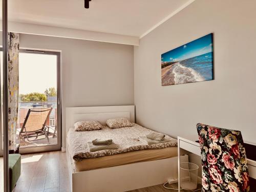 a bedroom with a bed and a balcony at Baltic Inspiration - Guest Favorite, Excellent Location, 2 King Bedrooms, Jacuzzi Bath, Parking in Gdańsk