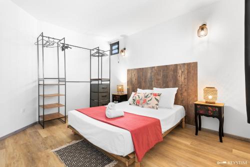 a bedroom with a bed with a red blanket at Ti Kaz Zépices - T2 avec grande terrasse in Le Tampon