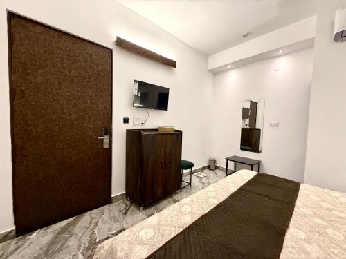 a bedroom with a large door in a room at HOTEL ATULYAM STAYs PREMIUM in Prayagraj
