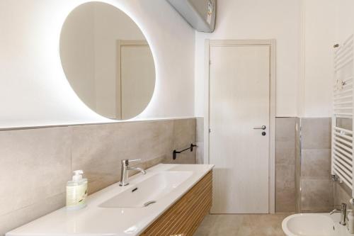 une salle de bain avec un lavabo et un miroir dans l'établissement Bright Apartment Segneri M4, à Milan