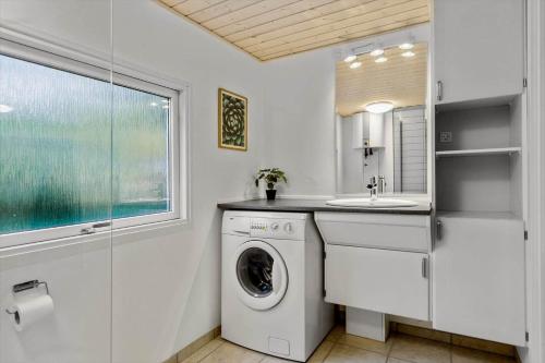 a bathroom with a washing machine and a sink at 8963-Orsted-Spovevej-6 in Ørsted