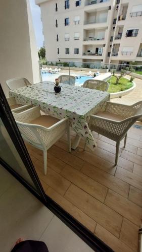 a table and chairs on a balcony with a pool at Résidence Blue Bay Monastir Sousse in Monastir