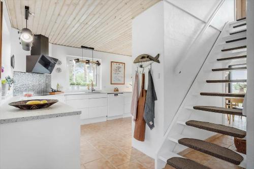 a kitchen with white walls and a spiral staircase at 8997-Orsted-Rougsovej-326-B in Ørsted